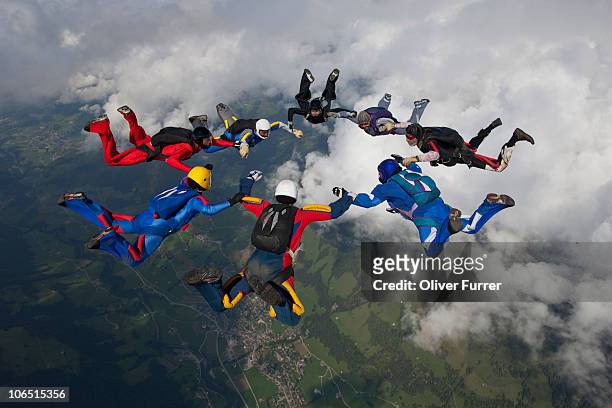 skydiving team members are building a sky star. - tomber en chute libre photos et images de collection