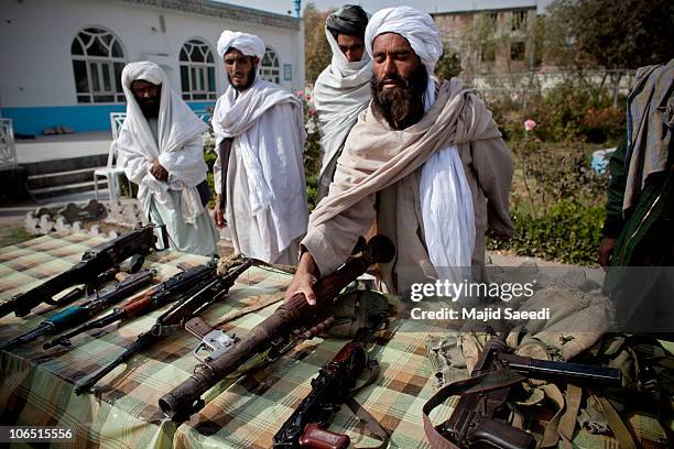 Surrendering Taliban militants stand with their weapons as they are presented to the media on November 4, 2010 in Herat, Afghanistan. Twenty Taliban...