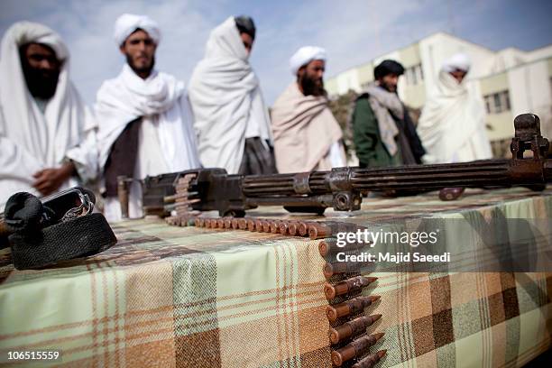 Surrendering Taliban militants stand with their weapons as they are presented to the media on November 4, 2010 in Herat, Afghanistan. Twenty Taliban...