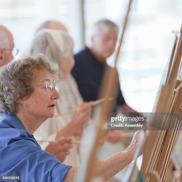 group of seniors learning to paint in art class - art class stockfoto's en -beelden