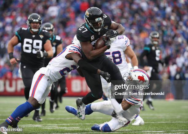 Leonard Fournette of the Jacksonville Jaguars runs with the ball in the second quarter as he is tackled by TreDavious White of the Buffalo Bills and...