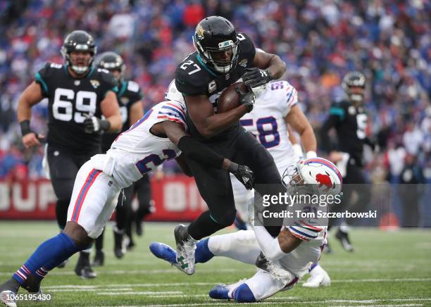 Leonard Fournette of the Jacksonville Jaguars runs with the ball in the second quarter as he is tackled by TreDavious White of the Buffalo Bills and...