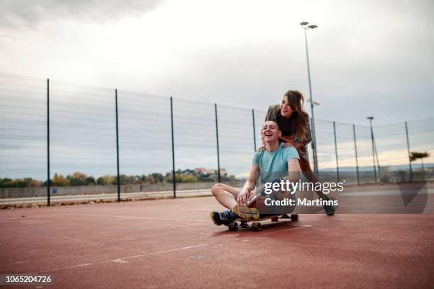 a happy girl and a boy with disability taking a break and laughing in the middle of their basketball game - disabled extreme sports stock pictures, royalty-free photos & images