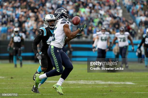 Tyler Lockett of the Seattle Seahawks catches a pass against Captain Munnerlyn of the Carolina Panthers in the fourth quarter during their game at...