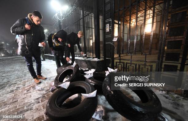People place paper boats in front of the Russian Embassy in Kiev late on November 25 during a protest following an incident in the Black Sea off...