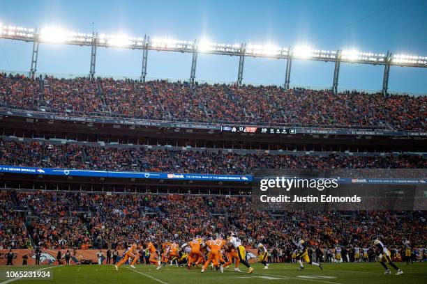 Quarterback Case Keenum of the Denver Broncos hands the ball to running back Phillip Lindsay in a general view during the third quarter of a game at...