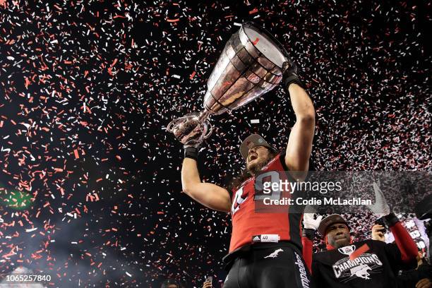 Alex Singleton of the Calgary Stampeders hoists the Grey Cup after defeating the Ottawa Redblacks during the second half of the Grey Cup at...