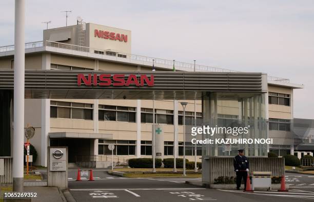 Security guard stands at an entrance of Japan's Nissan Motor's Oppama plant in Yokosuka, Kanagawa prefecture, on November 26, 2018. - The board of...