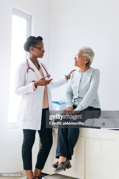 senior patiente consulte les jeune femme médecin - adult patient with doctor and stethoscope photos et images de collection