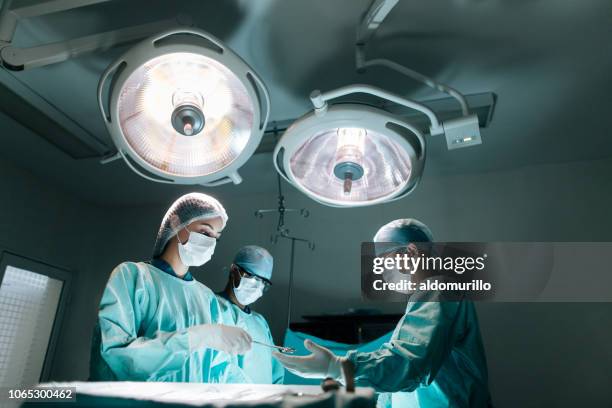 cirujano latino y asistentes en cirugía - flu mask in mexico fotografías e imágenes de stock