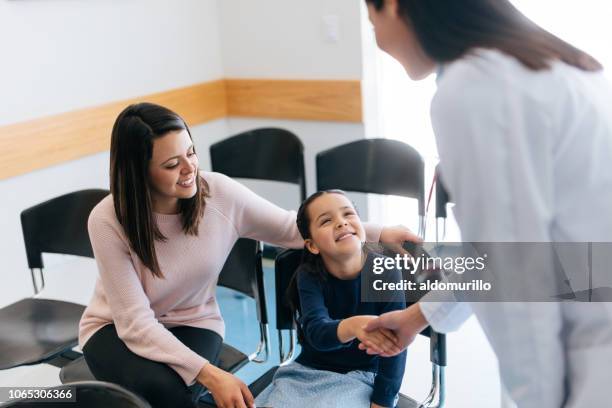 vrouwelijke arts schudden handen met meisje in wachtruimte - ranking stockfoto's en -beelden