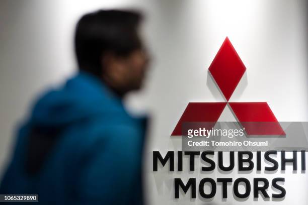 Member of the media walks past the Mitsubishi Motors Corp. Logo at the company's headquarters on November 26, 2018 in Tokyo, Japan. Mitsubishi...