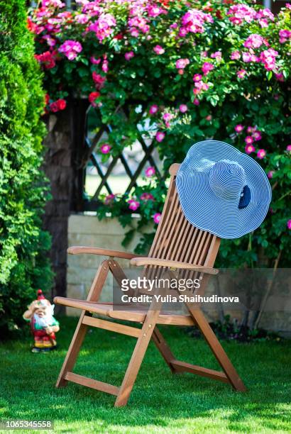 chaise lounge chair at the garden with a hat on it - 庭の置物 ストックフォトと画像