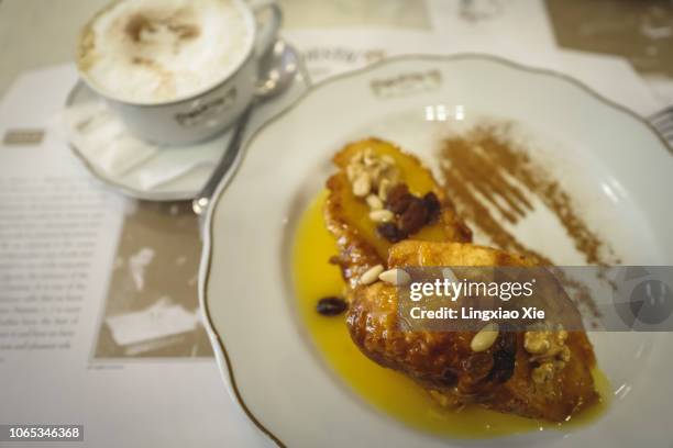 french toast with pine nuts, walnuts, raisins and a sauce of eggs and syrup, dusted with cinnamon - porto portugal food stock pictures, royalty-free photos & images