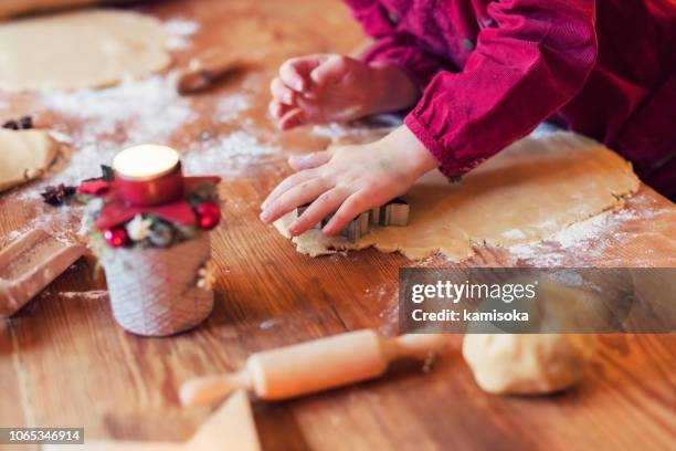 echte weihnachtsbäckerei - kind macht weihnachtsplätzchen - holztisch perspektive stock-fotos und bilder