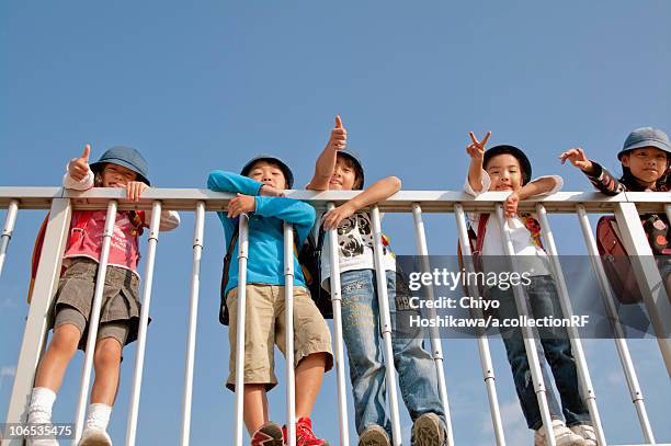 boys and girls giving thumbs up and peace sign, low angle view, japan - 子供のみ ストックフォトと画像