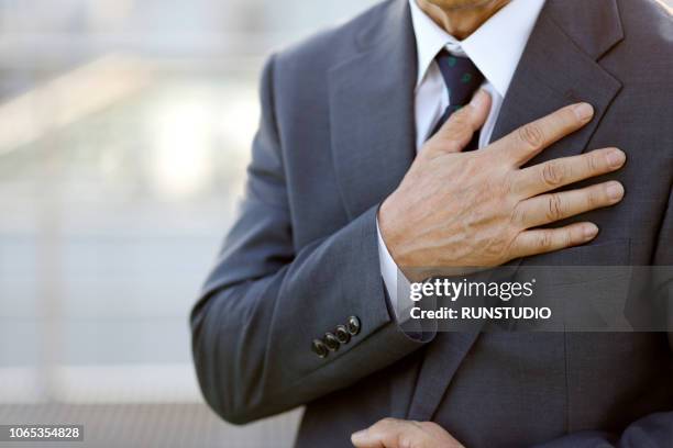 close-up of senior businessman with hand on chest - hand on chest stock pictures, royalty-free photos & images