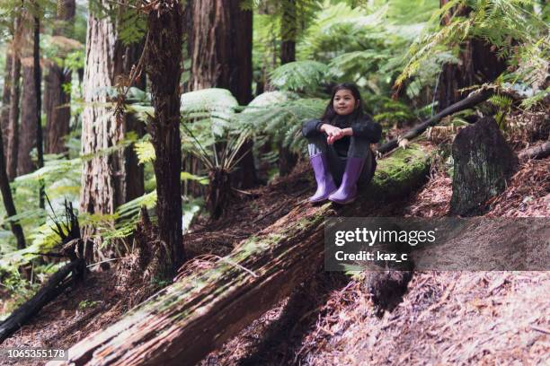 girl sitting on a fallen tree trunk - bush stock pictures, royalty-free photos & images