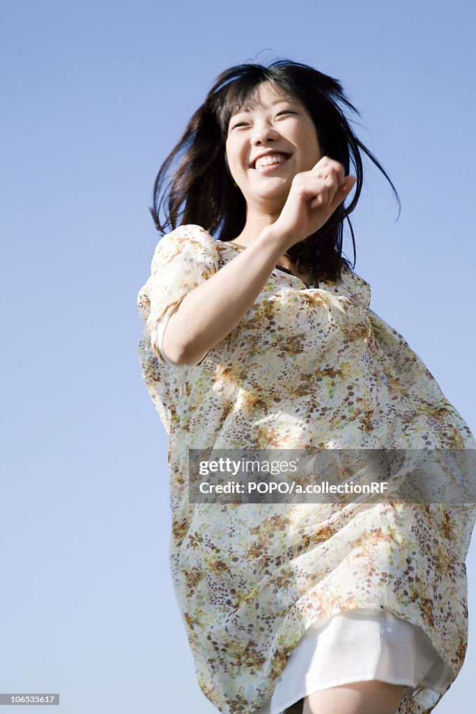 Young Woman Running Under Blue Sky