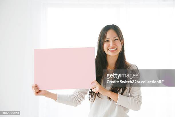 young woman holding pink rectangle - ボード　持つ　女性 ストックフォトと画像