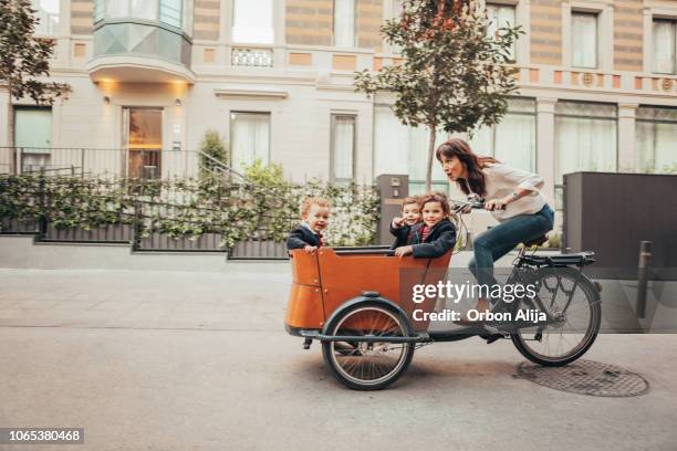 mutter reiten fahrrad - drei kinder stock-fotos und bilder