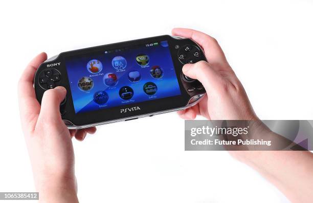 Detail of a person playing a 1st generation Sony PlayStation Vita handheld video game console , taken on January 12, 2012.