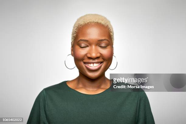young businesswoman smiling with eyes closed - woman portrait eyes closed stock-fotos und bilder