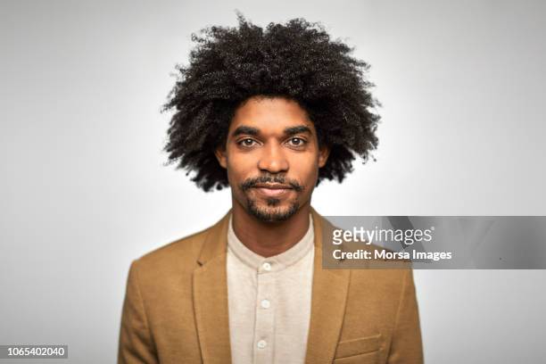 close-up portrait of confident young businessman - afro frisur stock-fotos und bilder