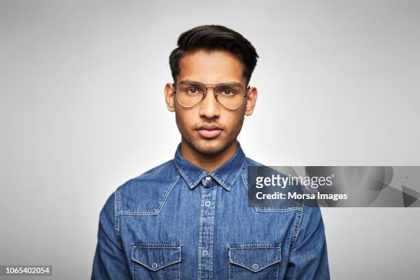 portrait of young businessman wearing eyeglasses - indian faces stock-fotos und bilder