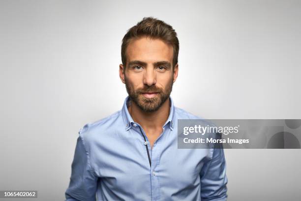 portrait of young businessman wearing blue shirt - homme barbe fond blanc photos et images de collection