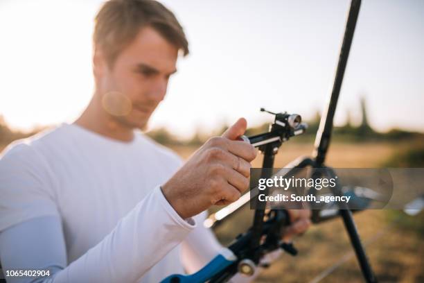 archer adjusting bow - arrow bow and arrow stock pictures, royalty-free photos & images
