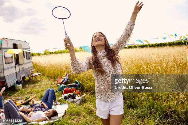 girl playing badminton on a field next to a caravan - playing badminton stock-fotos und bilder
