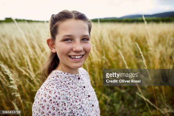 portrait of smiling girl in rural landscape - 12 13 jahre mädchen stock-fotos und bilder