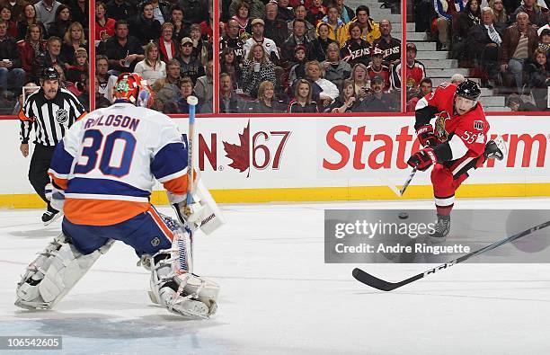 Sergei Gonchar of the Ottawa Senators shoots the puck, scoring the opening goal of the game against Dwayne Roloson of the New York Islanders at...