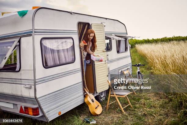 young woman eating watermelon in caravan - caravan stock-fotos und bilder