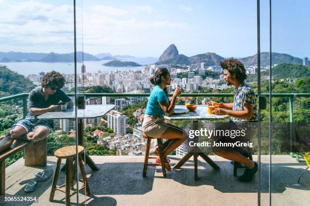 brasilianisches ehepaar auf terrasse, zuckerhut im hintergrund - hostel people travel stock-fotos und bilder