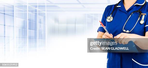 nurse in blue uniform writing - nhs staff fotografías e imágenes de stock