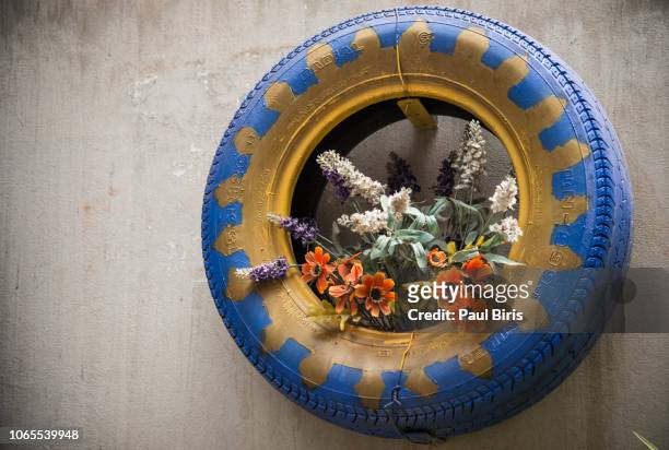 creative flat tire flower pot, hanoi old town, vietnam - autoreifen natur stock-fotos und bilder