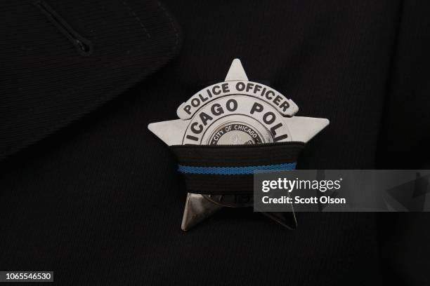 Police officer wears a mourning band on his badge as his department mourns Chicago Police Officer Samuel Jimenez during his graveside service at...