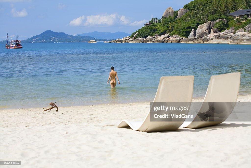 Sun bed and girl on a sea beach