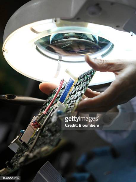 An employee checks a printed circuit board at Texcel Technology Plc.'s factory in Dartford, U.K., on Thursday, Nov. 4, 2010. The U.K. Faces a budget...