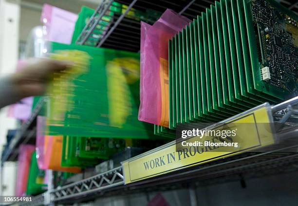 An employee removes a printed circuit board from a shelf at Texcel Technology Plc.'s factory in Dartford, U.K., on Thursday, Nov. 4, 2010. The U.K....