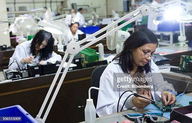 Employees work on printed circuit boards at Texcel Technology Plc.'s factory in Dartford, U.K., on Thursday, Nov. 4, 2010. The U.K. Faces a budget...