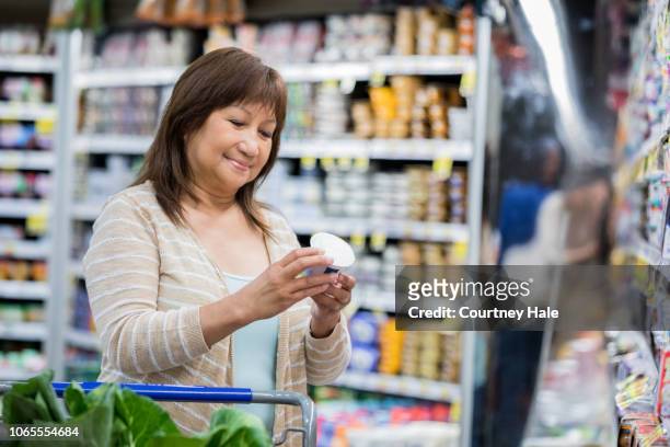 senior adult asian female is shopping at a grocery store - beautiful filipino women stock pictures, royalty-free photos & images