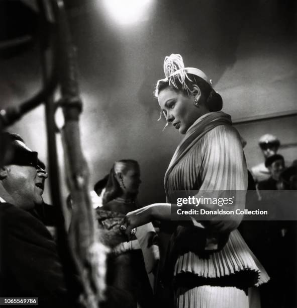 Actress Gene Tierney a director Walter Lang in a scene from the movie "On the Riviera"