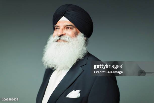 portrait confident, well-dressed senior man with beard wearing turban - sijismo fotografías e imágenes de stock