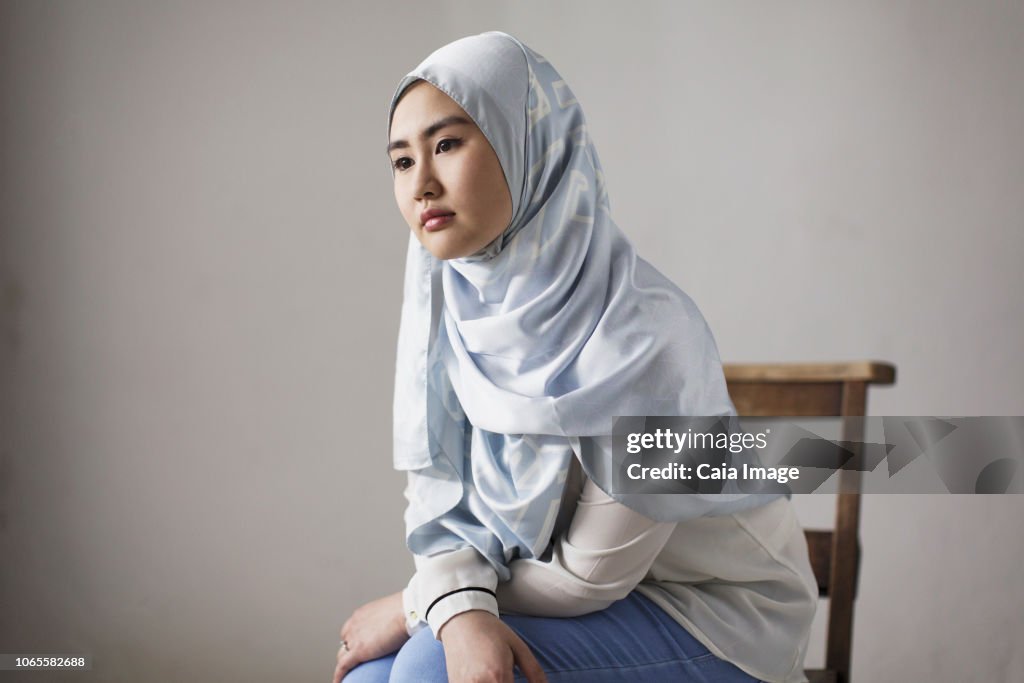 Thoughtful young woman in blue silk hijab
