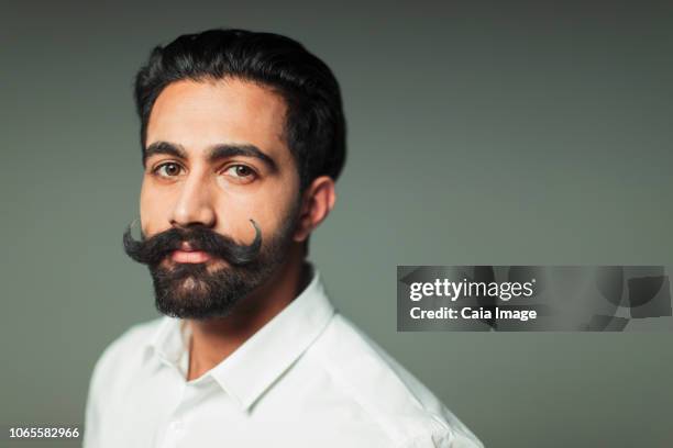portrait confident young man with handlebar mustache - handlebar moustache stock pictures, royalty-free photos & images