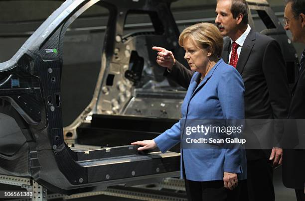 German Chancellor Angela Merkel, accompanied by BMW Chairman Norbert Reithofer and BMW head of development Klaus Draeger, examines a carbon-fiber car...