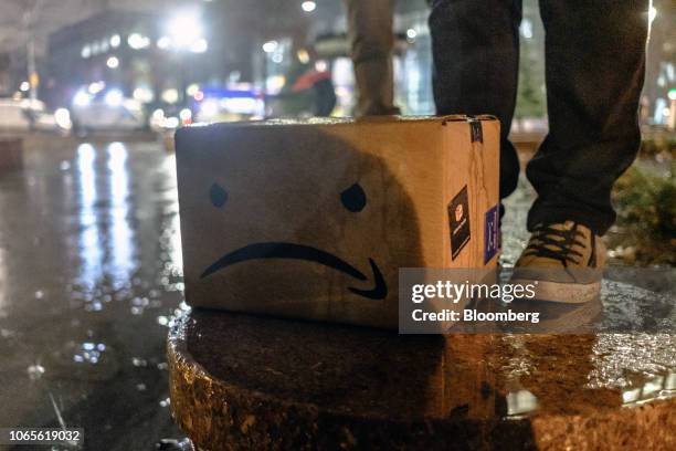 Cardboard box featuring an altered version of the Amazon.com Inc. Logo sits on the ground during a protest against the planned Amazon office hub in...